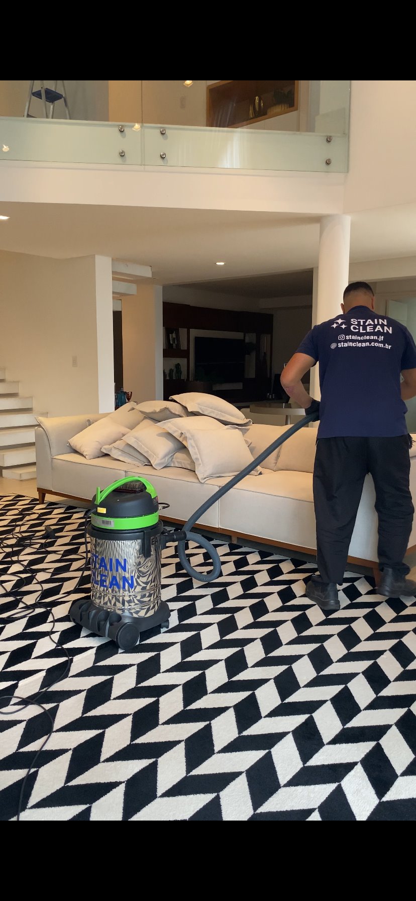 Profissional da Stain Clean higienizando sofá em residência de Juiz de Fora