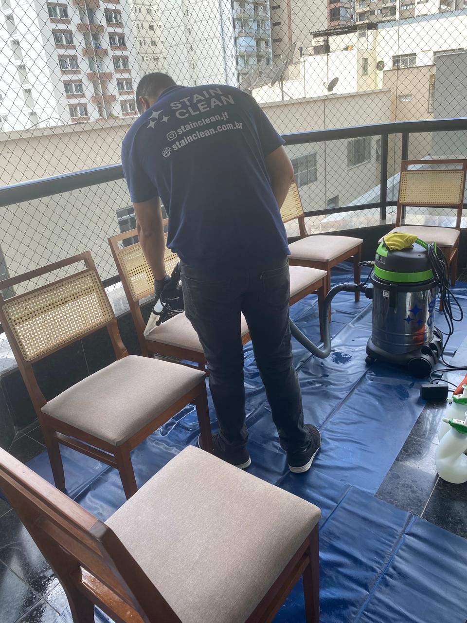 Profissional da Stain Clean higienizando cadeiras em atendimento residencial